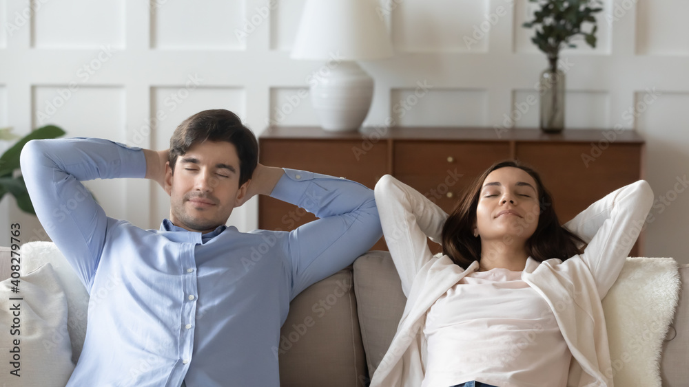 Obraz premium Close up young woman and man resting, sleeping, leaning back with closed eyes and hands behind head on couch, spending weekend together, couple taking nap, relaxing on cozy sofa at home
