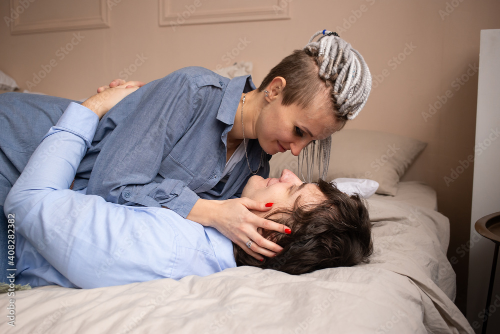 Saint Valentine's Day. Beautiful young couple in bedroom is kissing while lying on bed. Enjoying spending time together. Saint Valentine's Day. Beautiful young couple in bedroom is kissing while lying on bed. Enjoying spending time together.