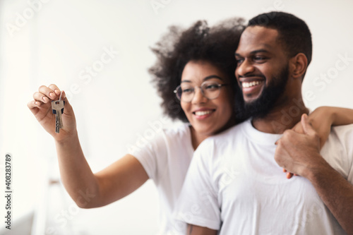 Happy African Couple Holding New House Key Hugging Standing Indoor