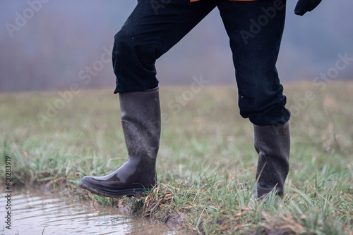 Schritt ein eine Pfütze auf einer überfluteten Wiese während eines Hochwasser