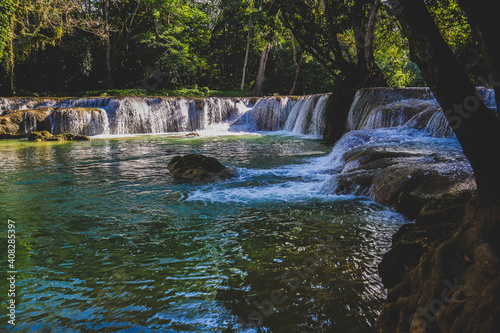 Deep forest waterfall stream view. Forest waterfall creek. Waterfall in deep forest. Waterfall river forest scene