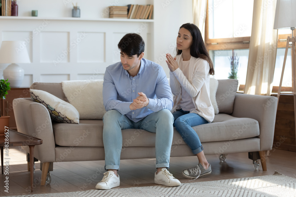 Frustrated guilty wife asking forgiveness, making peace with offended husband after quarrel or cheating, sad man ignoring woman, not talking, family crisis, relationship problem, break up and divorce