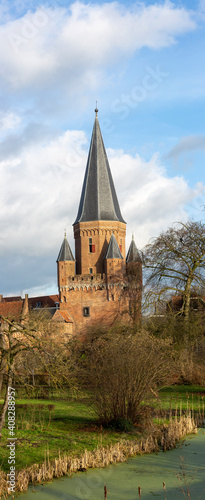 Long vertical frame with cityscape of medieval Hanseatic city Zutphen in The Netherlands with the Drogenaps tower against a blue sky with clouds