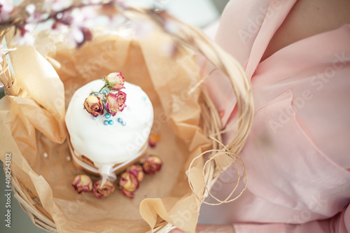 Woman hands holding traditional russian easter cake on table. The decorarion of kulich are the flower are eating on spring holiday photo