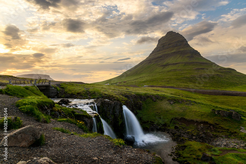 View of Kirkjufell mountain and waterfalls lit by midnight sun in smmer. Northern Iceland.