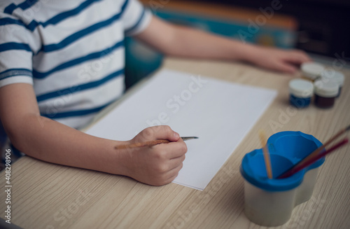 Small boy draws at the table. Top view