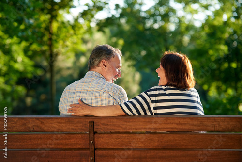 Happy retired couple on the bench. Back view senior man and woman outdoors in the park. © DenisProduction.com