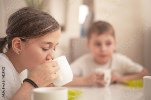 The group of kids eating the easter bread on spring holiday with tea