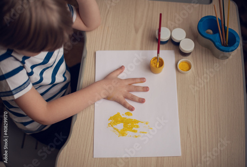 Small boy draws at the table. Top view