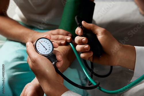 doctor measures blood pressure of a patient close up