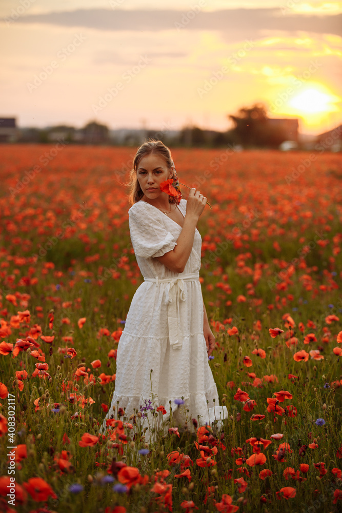 Portrait of a woman on a background of sunset and red flowers Portrait of a woman on a background of sunset and red flowers