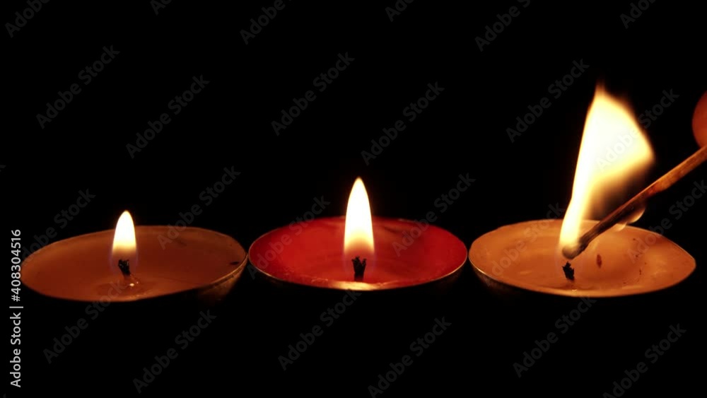 Igniting candles in black background, three cozy home interior, burning and extinguishing flame Igniting candles in black background, three cozy home interior, burning and extinguishing flame