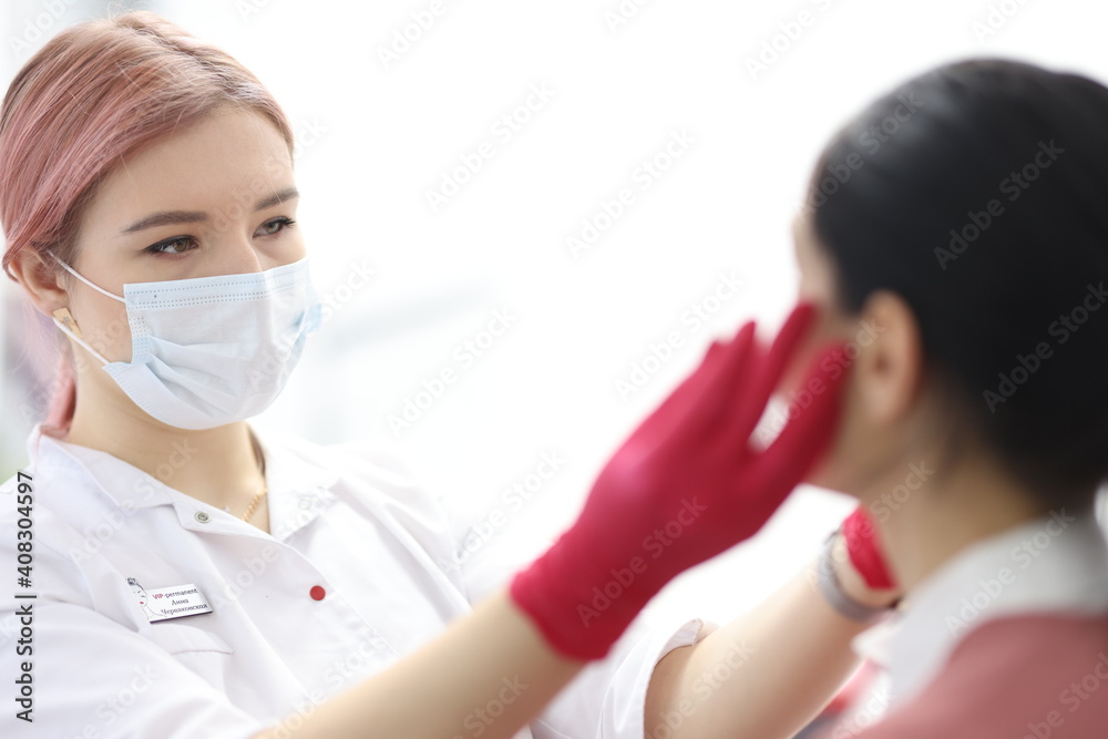 Woman make-up artist in protective mask makes procedure to client in beauty salon Woman make-up artist in protective mask makes procedure to client in beauty salon