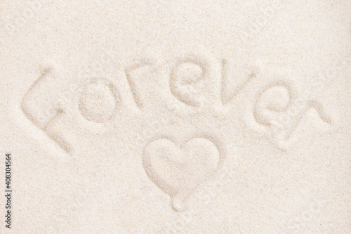 Word Forever writing on sand background and heart shape sign above view for wedding romantic invitation or love story