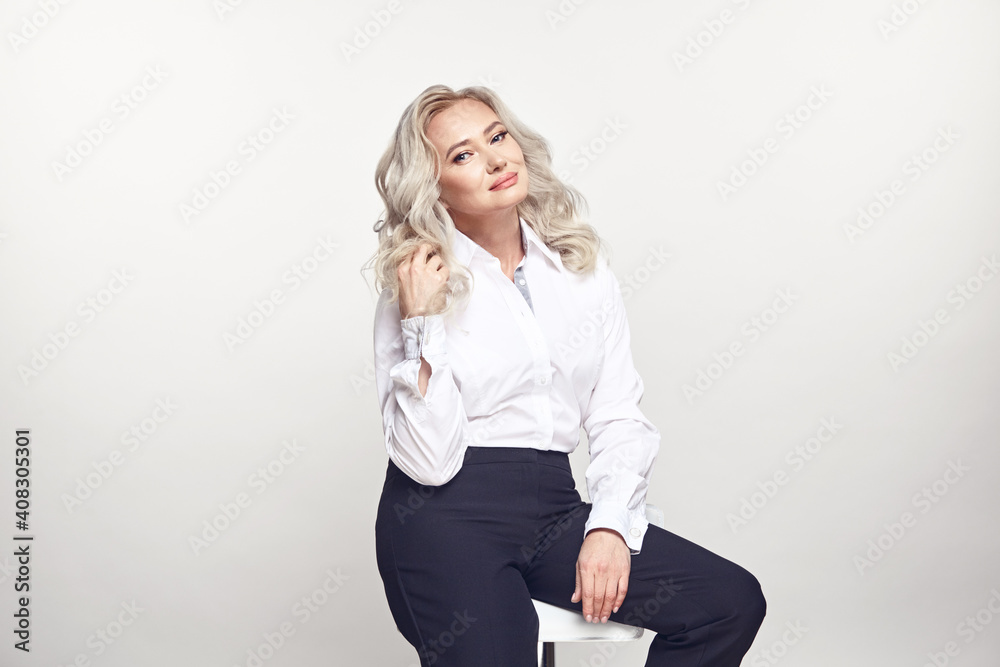 Business lady of fifty years wearing in stylish casual look, posing on isolated background. Business lady of fifty years wearing in stylish casual look, posing on isolated background.
