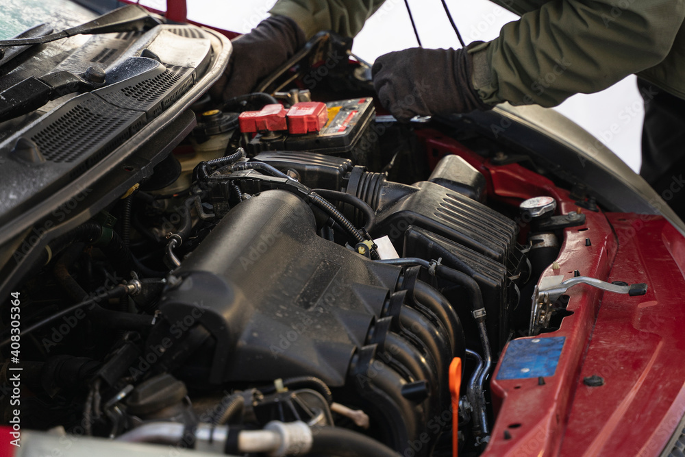 Worker's hands repair car, install new battery Worker's hands repair car, install new battery