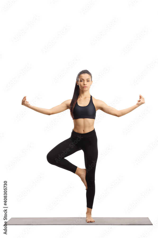 Full length portrait of a young female in a yoga pose on an exercise mat