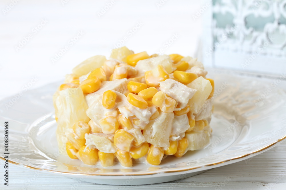 Salad with chicken, pineapple and corn with champagne on a white plate Salad with chicken, pineapple and corn with champagne on a white plate