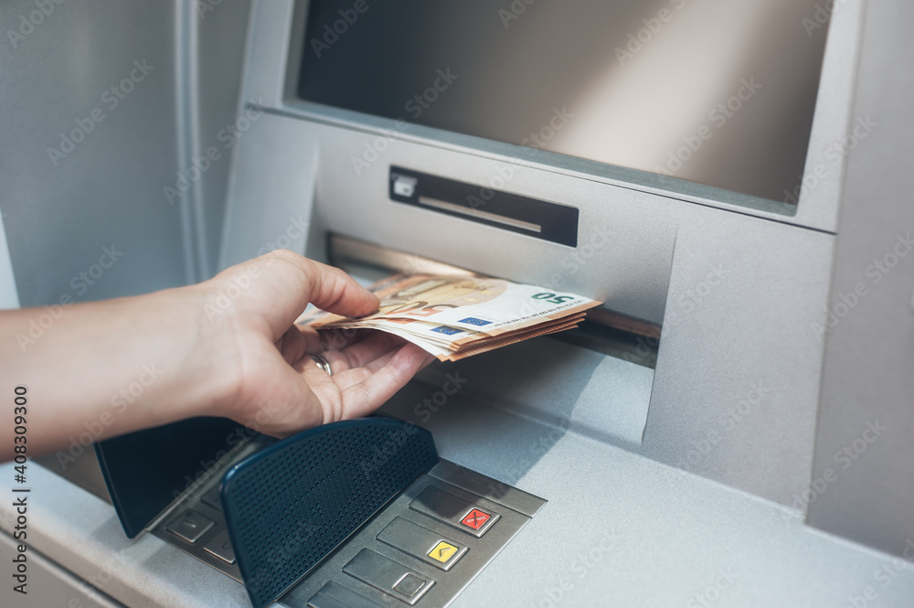 Woman hand taking money from bank cash ATM machine. Close up. Cash point. Finance, transactions, credit card, money withdraw, currency concept