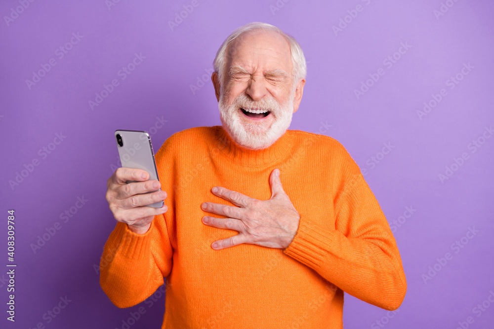 Photo of positive aged man closed eyes hand on chest laughing loud comedy blog post isolated on violet color background Photo of positive aged man closed eyes hand on chest laughing loud comedy blog post isolated on violet color background