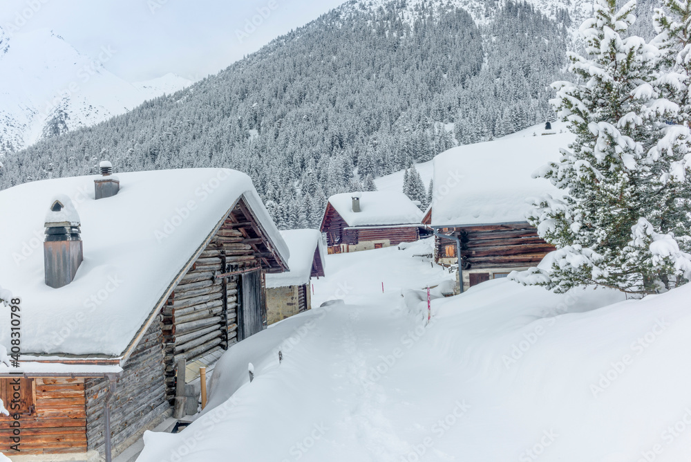 Isolated summer chalet and villages high up on the Swiss Alps covered in fresh powder snow near Davos