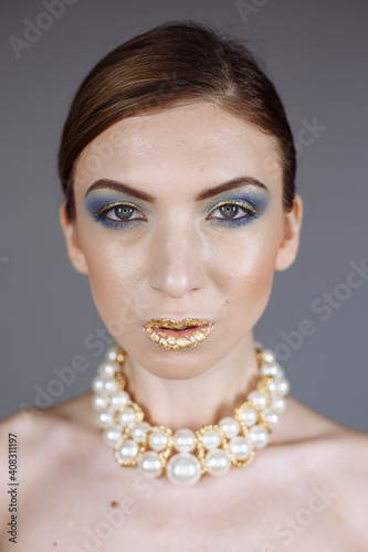 portrait of a girl with a large necklace and gold lips
