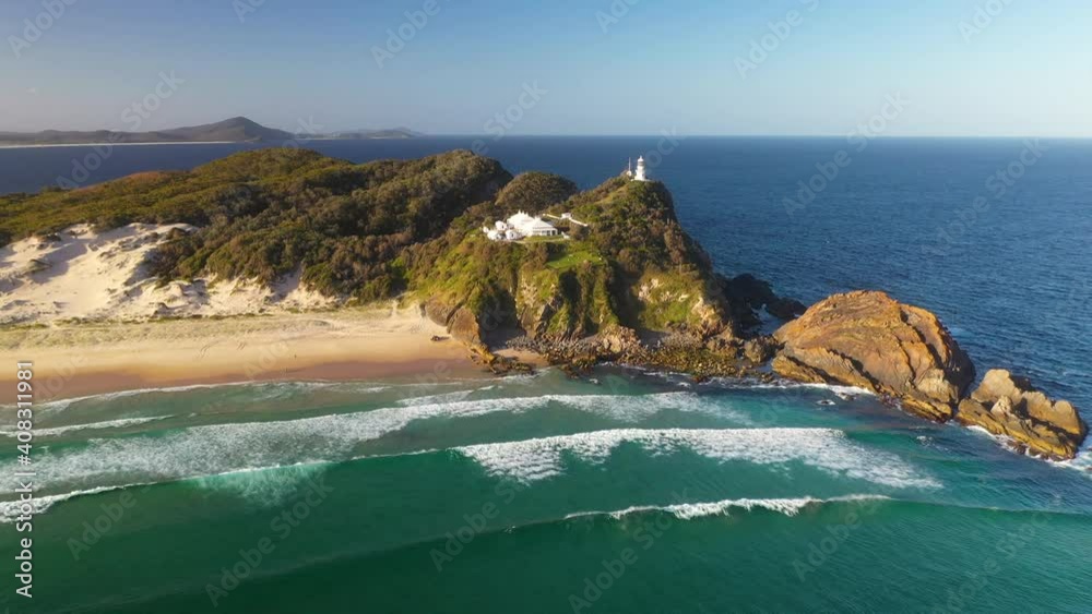 Sugarloaf Point Lighthouse on Australia headland clifftop, sunset aerial view