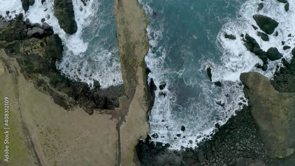 Aerial vertical view of sea waves crashing on rocky cliffs along the seashore. 4k. Slow motion. Aerial vertical view of sea waves crashing on rocky cliffs along the seashore. 4k. Slow motion.