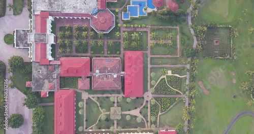 Top View Of Red-Painted Rooftops Of Hotel Buildings With Green Landscape At Lalit Golf And Spa Resort In Rajbagh Beach, Conacona, South Goa, India - Aerial Drone Shot photo