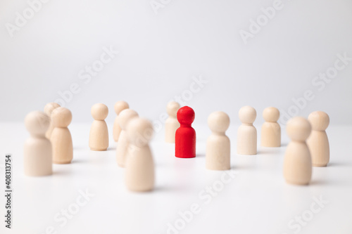 A wooden figure standing with a team to influence and empowerment. Concept of leadership  successful competition winner and Leader with influence and Social distancing for a new normal lifestyle