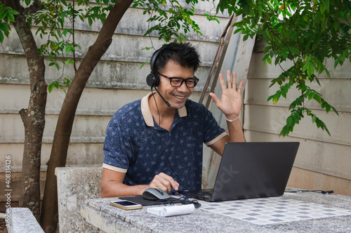 Men raise their hands to greet members at the meeting via video conference