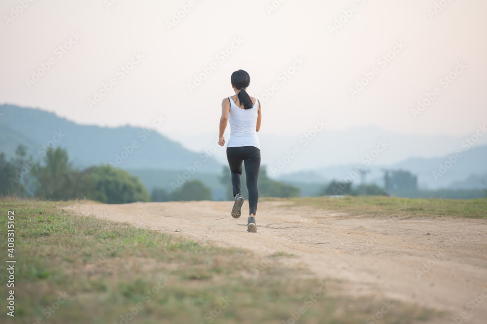 Young lady enjoying in a healthy lifestyle while jogging along a country road, exercise and Fitness and workout on outdoors. Young lady enjoying in a healthy lifestyle while jogging along a country road, exercise and Fitness and workout on outdoors.