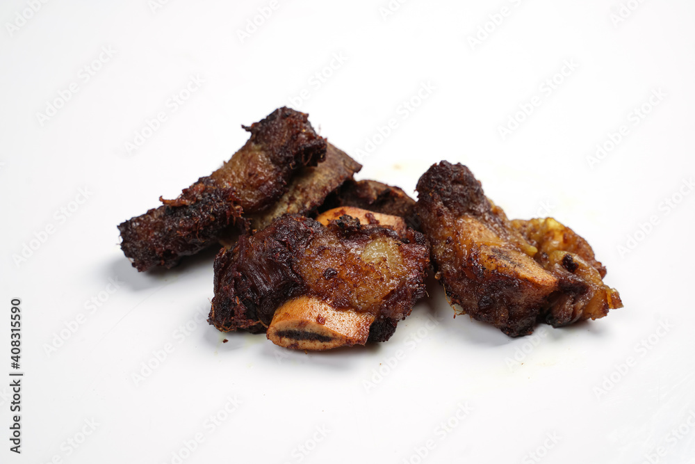 Small pieces of fried ribs that are dark brown in color. The beef ribs have been seasoned, then sprinkled with typical Indonesian spices. Spicy fried ribs. Fried ribs isolated on white background. Small pieces of fried ribs that are dark brown in color. The beef ribs have been seasoned, then sprinkled with typical Indonesian spices. Spicy fried ribs. Fried ribs isolated on white background.