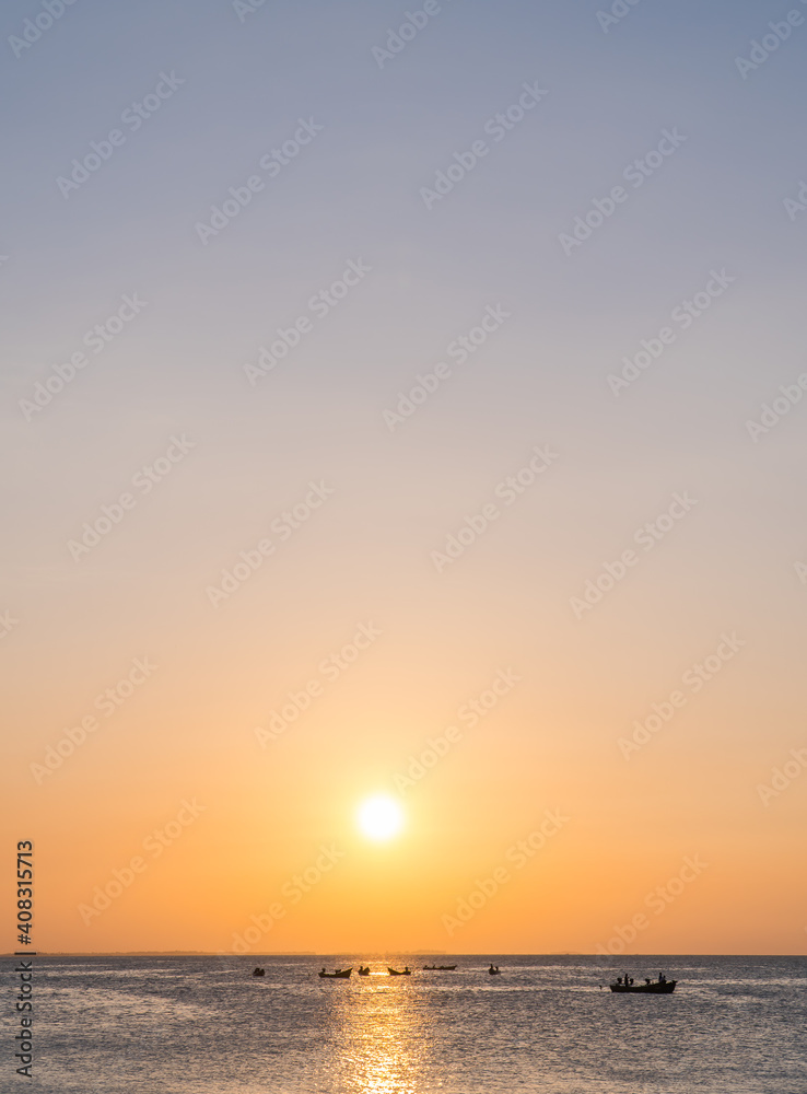 Sunset sky vertical over sea in the evening and fishing boat with colorful orange sunlight and sundown landscapes,Dusk sky.