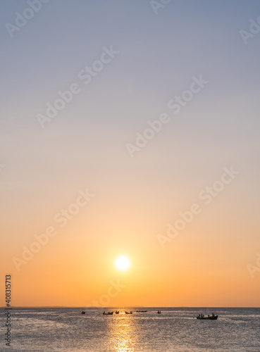 Sunset sky vertical over sea in the evening and fishing boat with colorful orange sunlight and sundown landscapes,Dusk sky. © Nature Peaceful 