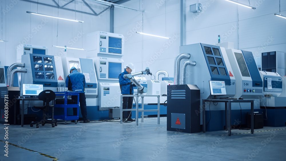 Fototapeta premium Modern Factory with Professional Workers, Engineers, Managers Working on Production Line, Workshop Management, Optimization. Industrial Facility: Equipped with CNC Machinery and robot arm Technology