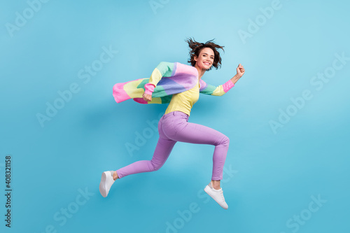 Fototapeta Naklejka Na Ścianę i Meble -  Photo portrait full body side view of running girl isolated on pastel blue colored background
