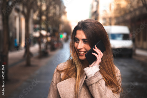 Young caucasian brunette woman using a smartphone at the street