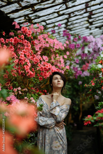 beautiful girl in a greenhouse with lilies meditates