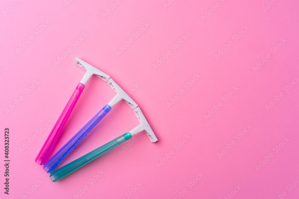 Female disposable razors on pink background top view Female disposable razors on pink background top view