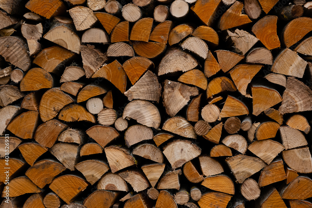 foreground of a pile of split firewood with ends of firewood of different shapes