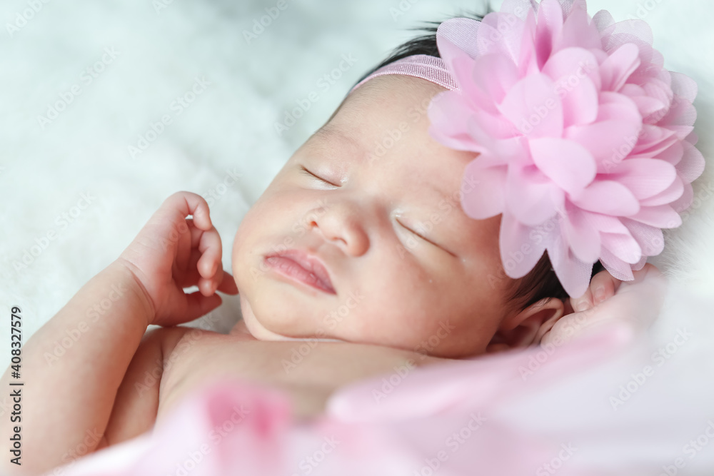 A beautiful newborn girl wearing a pink headband and sleeping on a white soft blanket, Infant, babyhood concept and copy space - Image A beautiful newborn girl wearing a pink headband and sleeping on a white soft blanket, Infant, babyhood concept and copy space - Image