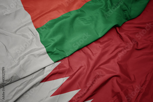 waving colorful flag of bahrain and national flag of madagascar.