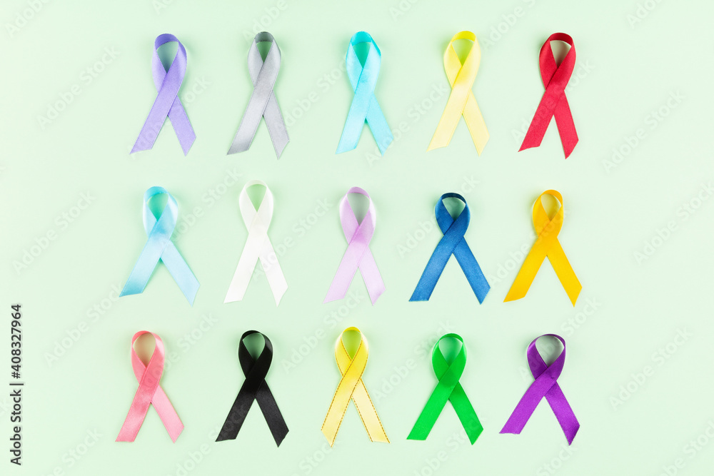 World cancer day background. Colorful ribbons, cancer awareness. Green background. Top view