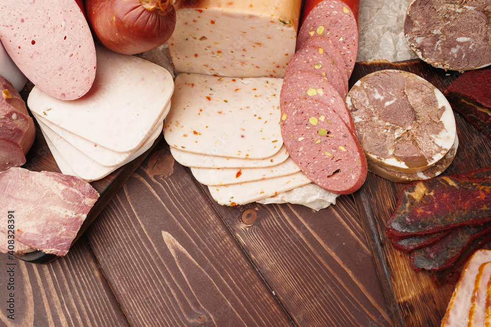 Assortment of different sausages laid out on brown wooden background Assortment of different sausages laid out on brown wooden background