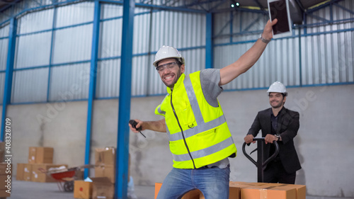 Warehouse worker and manager having fun in a large warehouse
