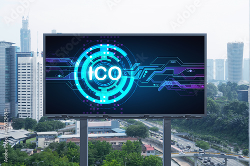 ICO hologram icon on billboard over panorama city view of Kuala Lumpur at day time. KL is the hub of blockchain projects in Malaysia, Asia. The concept of initial coin offering, decentralized finance