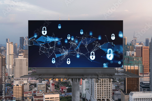 Padlock icon hologram on road billboard over panorama city view of Kuala Lumpur at sunset to protect business, Malaysia, Asia. The concept of information security shields.