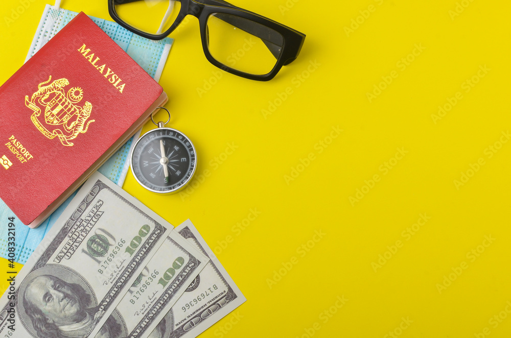 Passport with face mask, banknotes, compass and spectacles on yellow background. Travel and health concept.