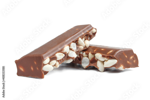 Foto Chunks of milk chocolate with puffed rice isolated on white background
